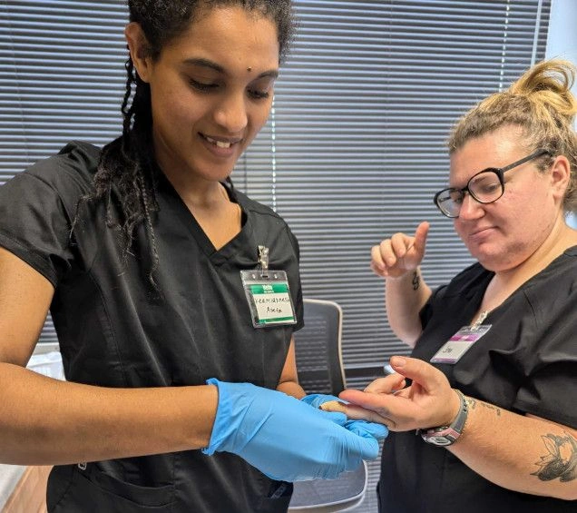 Medical student practicing finger prick for blood draw